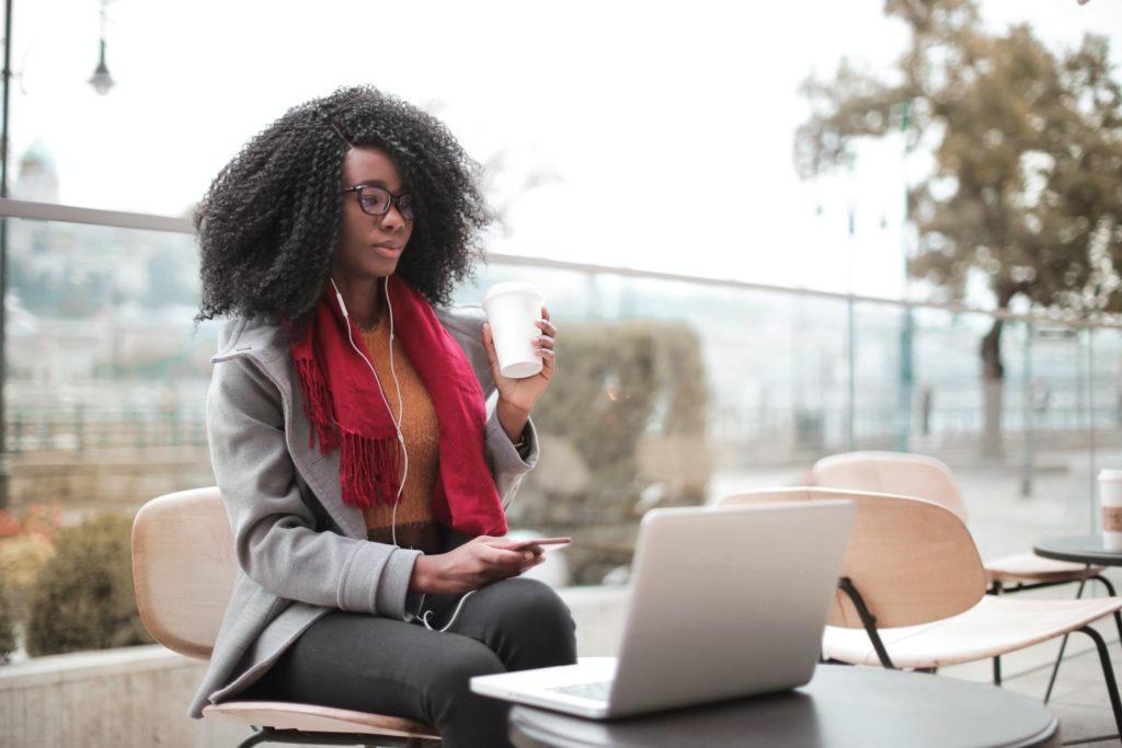 A girl with glasses listening to a website being read, representing the advantages of web accessibility for business websites.