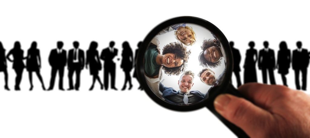 A person using a magnifying glass to view an audience
