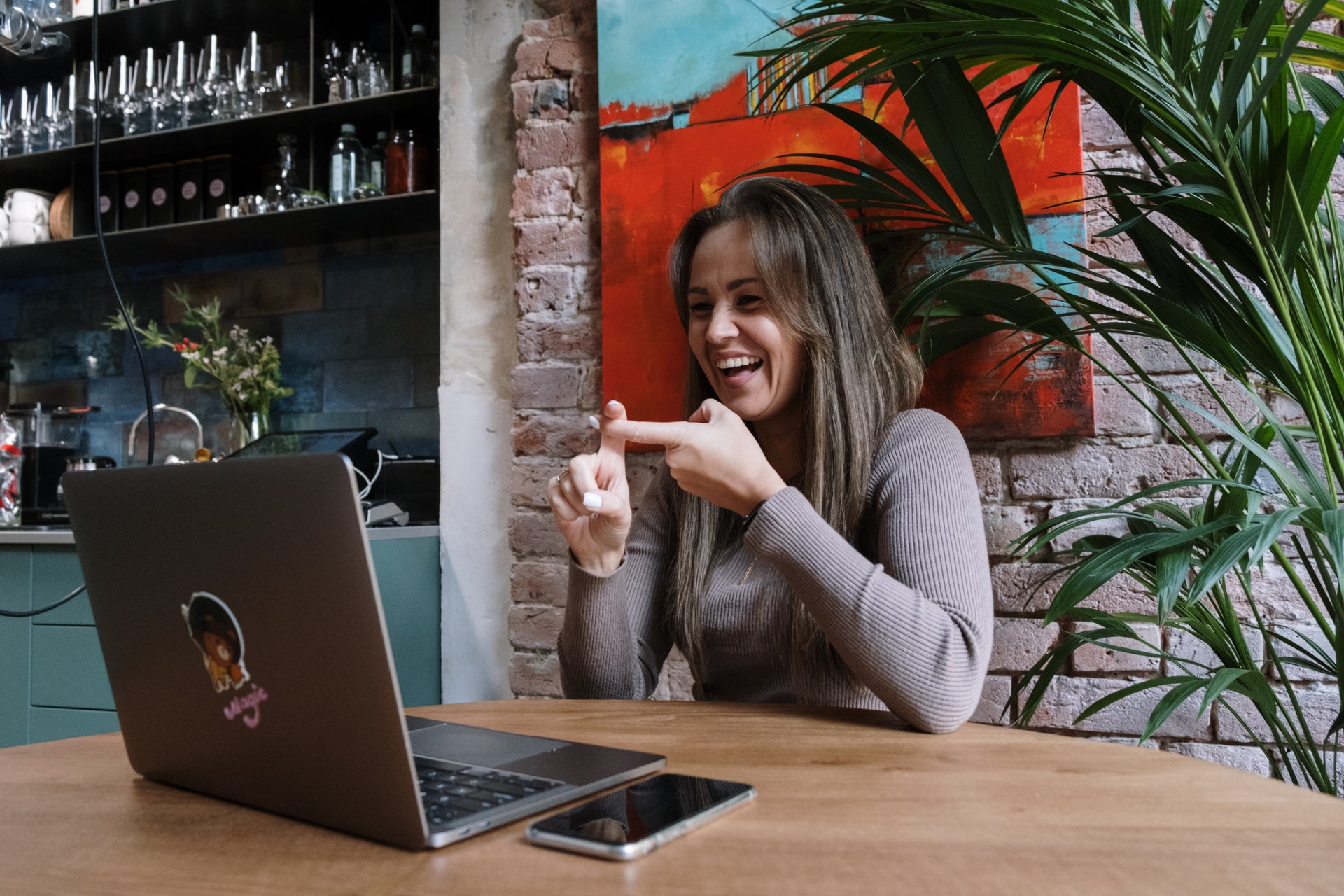 A girl with a disability smiling while using a laptop. (Photo by: cottonbro from Pexels)