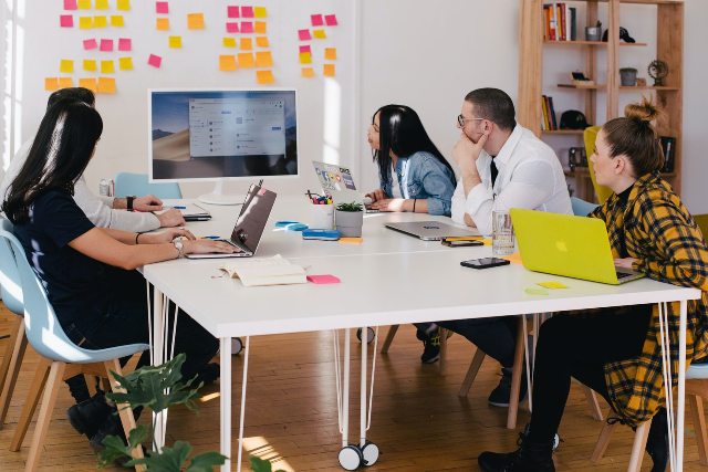 People in the office talking about how to develop a website maintenance plan in 2022.