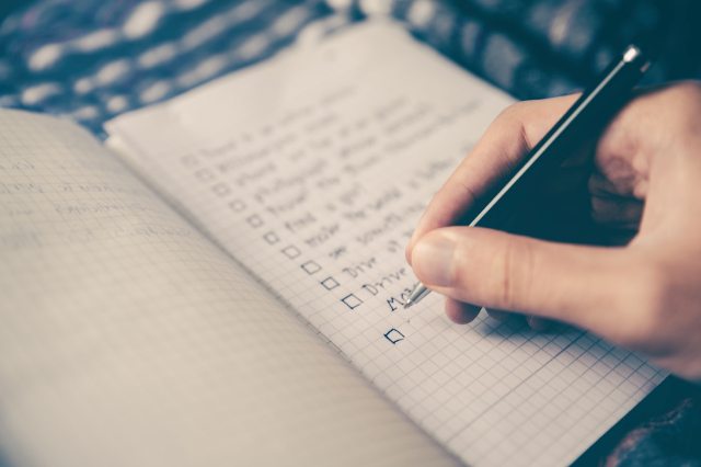 A woman crossing off items from the list. 
