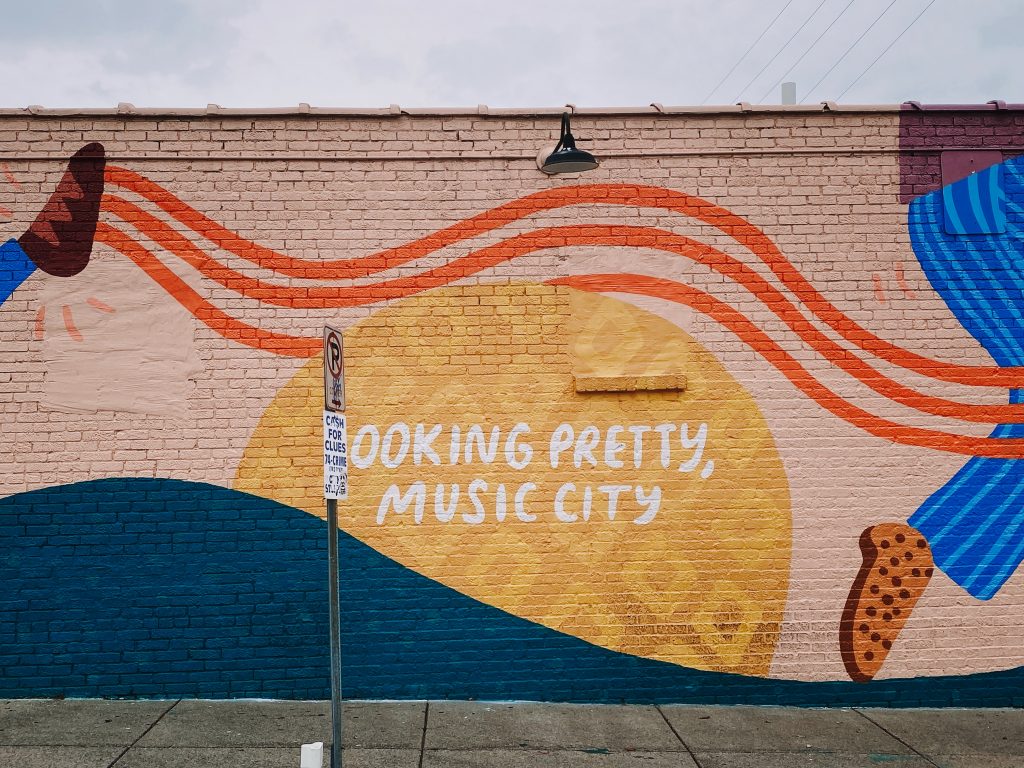 Graffiti wall in Nashville saying "Looking pretty, Music City" depicts the best Nashville neighborhoods for young families 