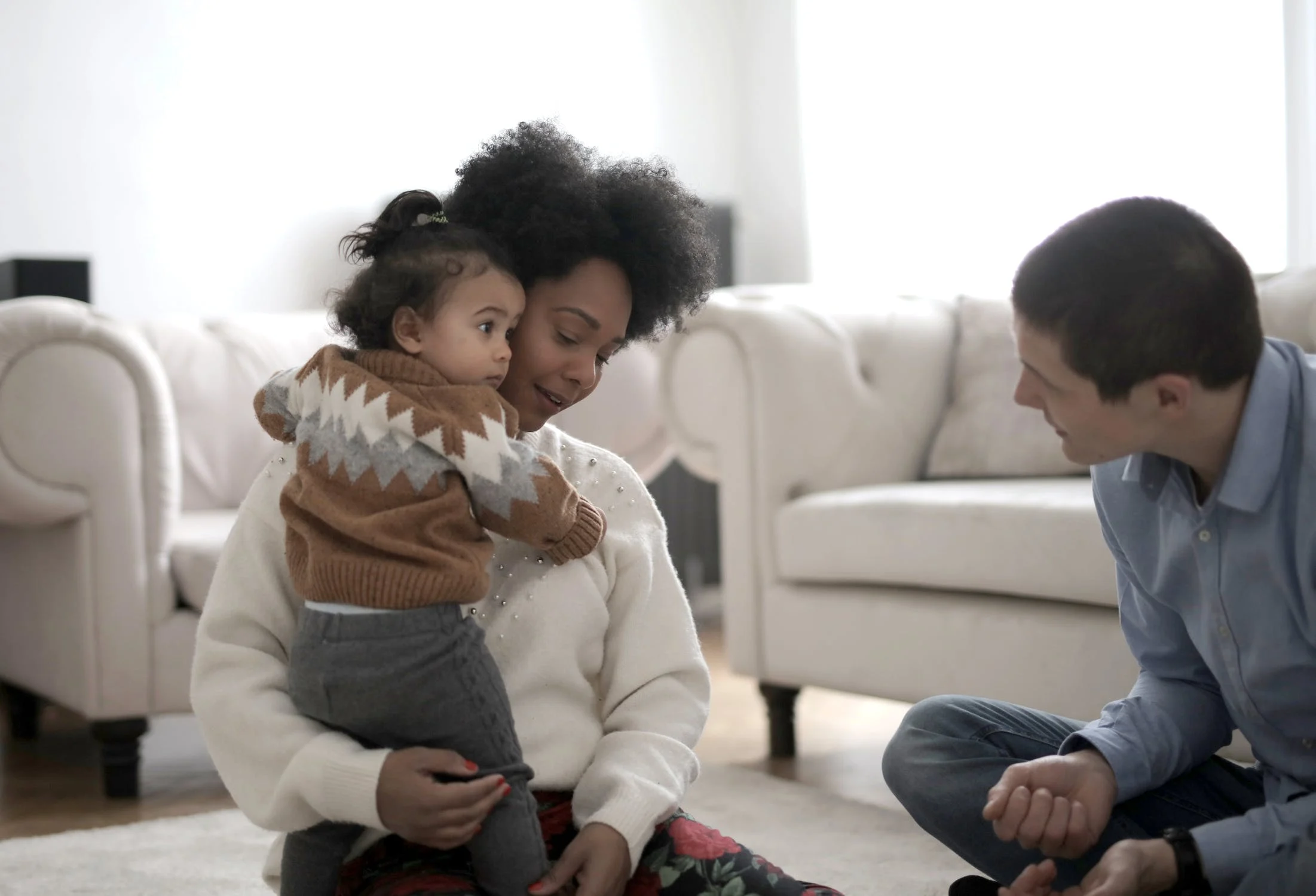A young couple playing with their kid in a new house