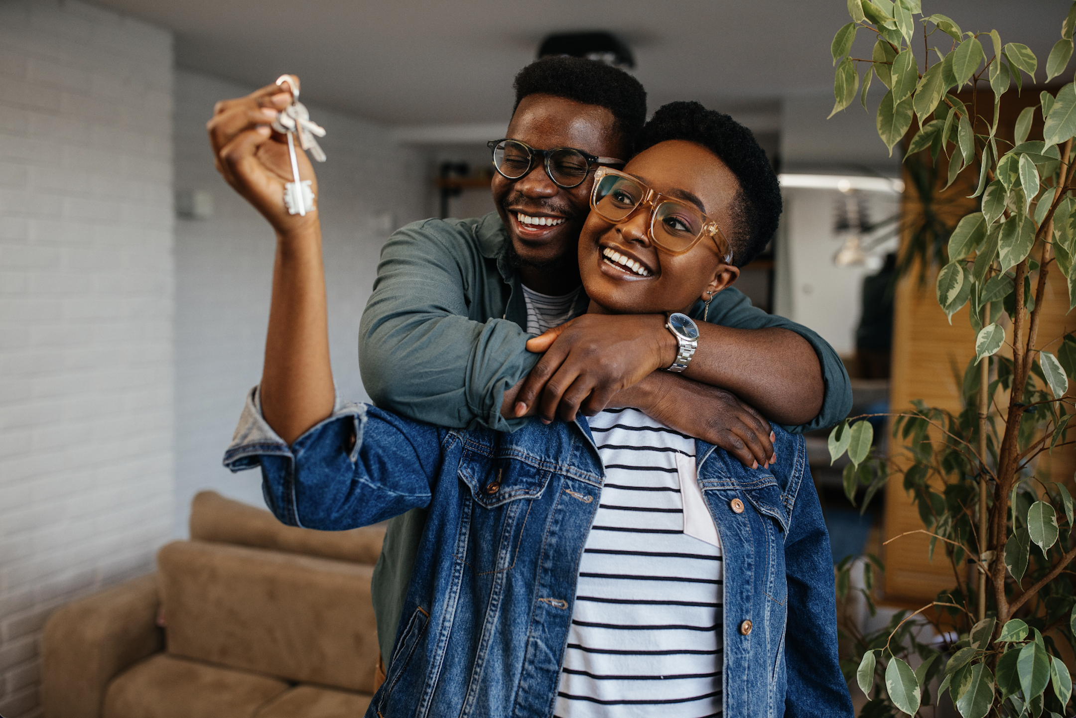 Couple showing off the key to their new home. (Photo by: bernardbodo | iStock via Getty Images Plus)