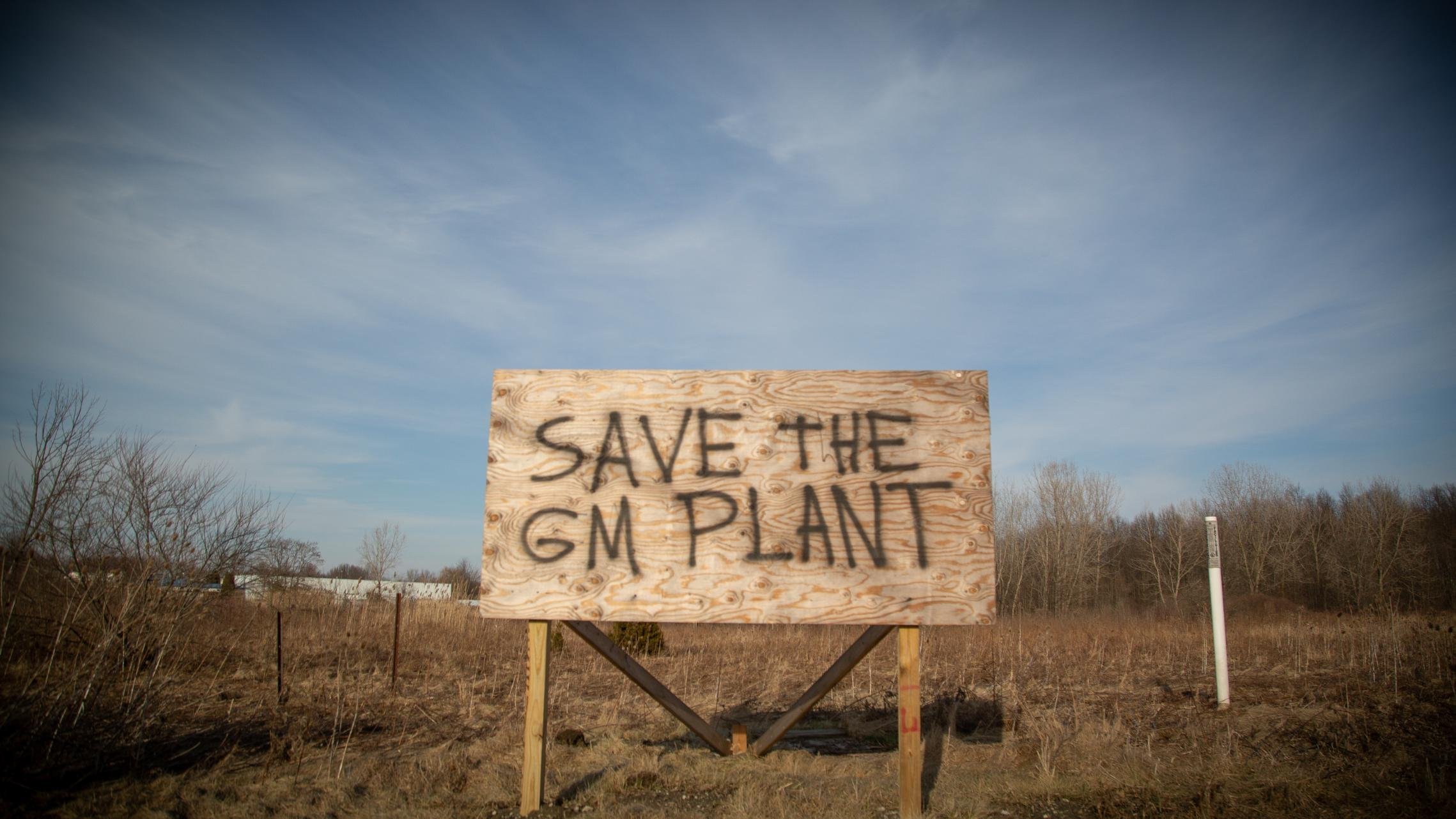 A spray painted billboard sign sits adjacent to the Lordstown GM plant