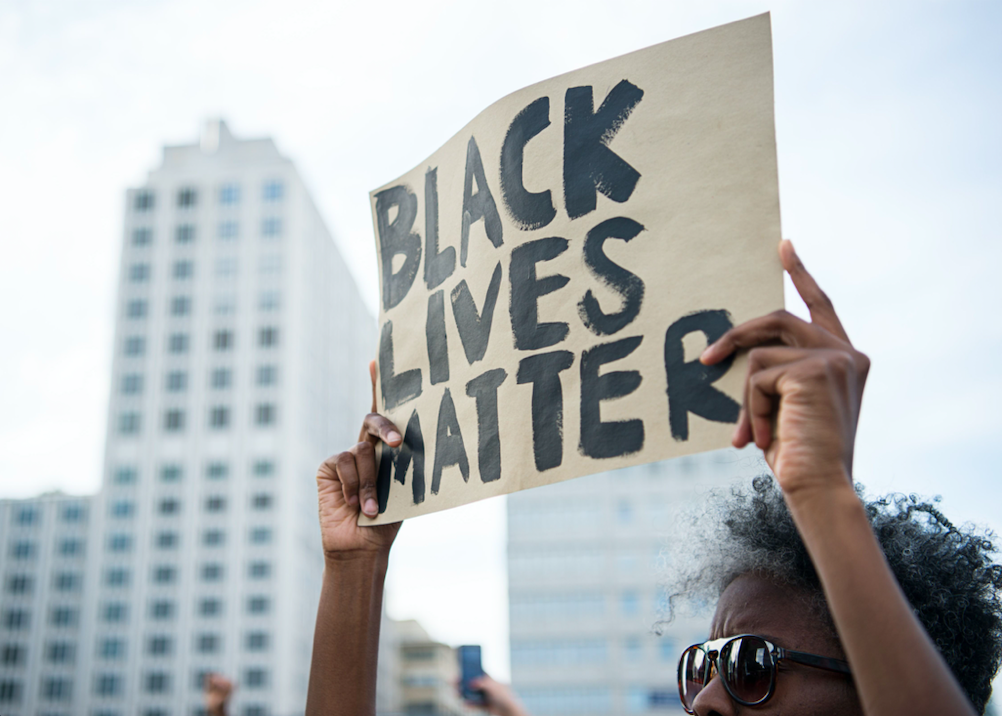 A protestor holds up a sign reading "Black Lives Matter" during a demonstration in Berlin, on July 10, 2016 with the motto "Black Lives Matter - No Justice = No Peace" as protest over the deaths of two black men at the hands of police last week.