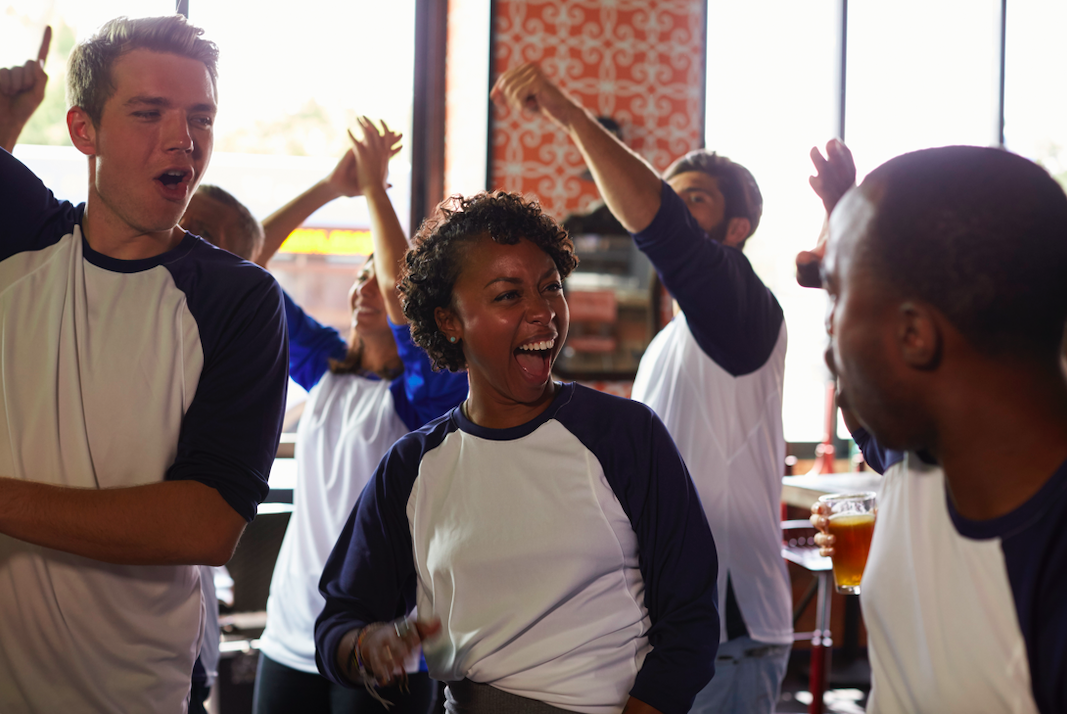 Friends Watching a Game In a Sports Bar Celebrating (Photo by: monkeybusiness)
