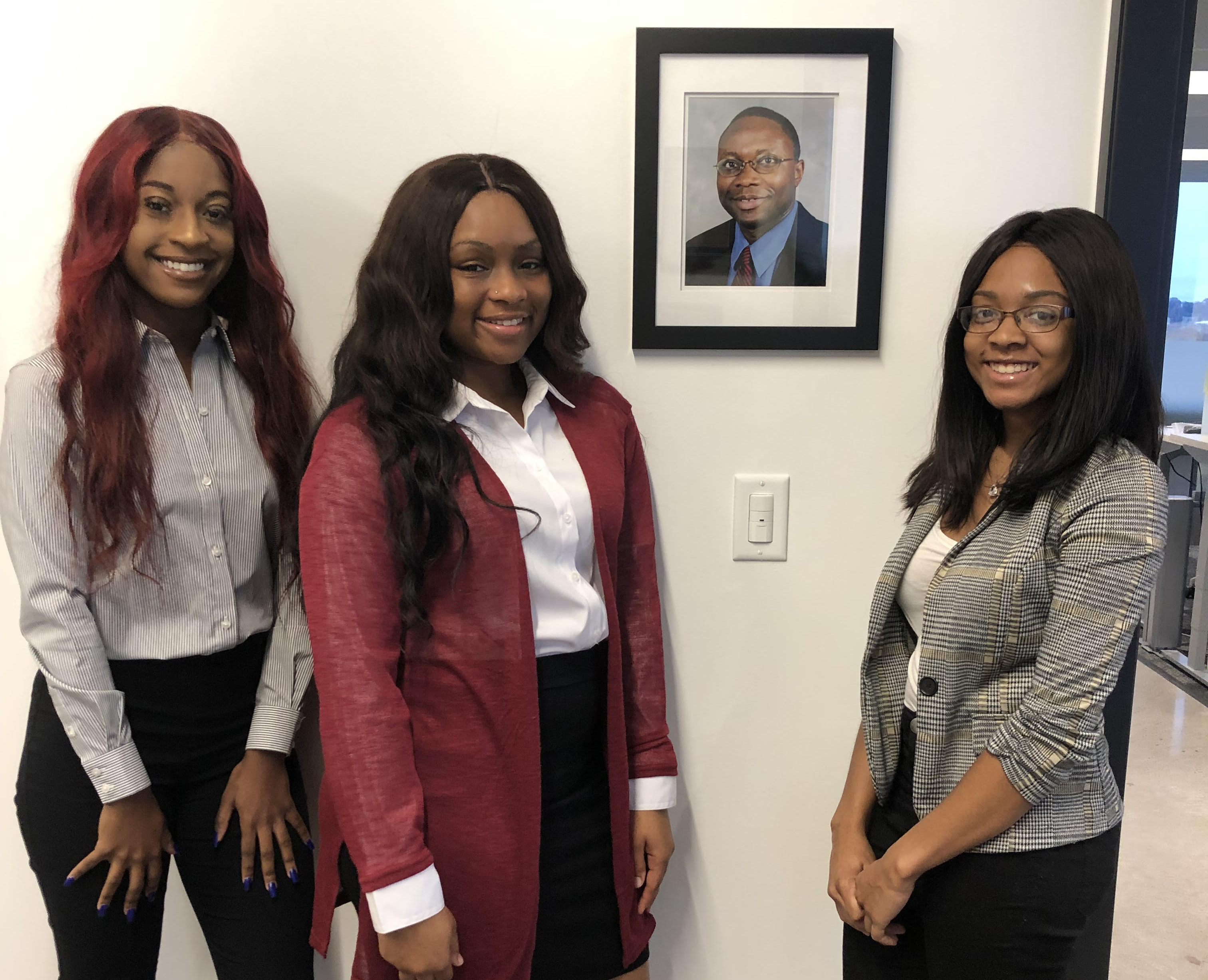 From left, Staff writer Brianna Sparrow, Editor-in-Chief KaBria Kirkham and Staff writer Nyah Peebles stand next to a photo of Deceased Tennessee Reporter and TSU Professor Getahn Ward