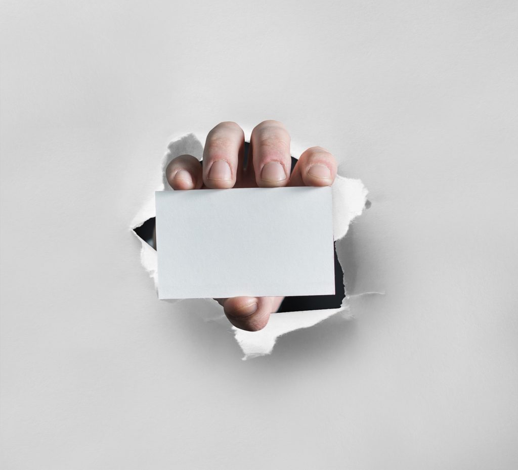 A hand breaking through the white paper showing the note