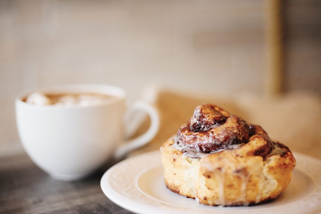A cinnamon bun and cup of coffee