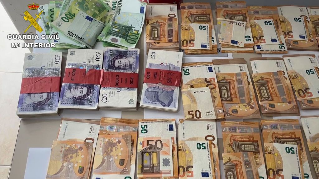 Spanish Civil Guard officers display some of the money they seized from a company accused of defrauding elderly British clients. (Spanish Civil Guard/Zenger)