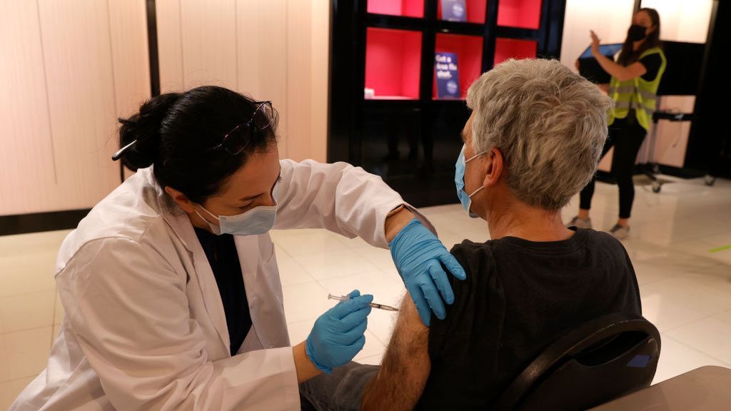 Safeway pharmacist Shahrzad Khoobyari administers a Pfizer COVID-19 booster vaccination into the arm of Norman Solomon at a clinic on Oct. 1 in San Rafael, California. A new study that influenced the decision to give boosters relied on Israeli Ministry of Health data indicating a decrease in vaccine effectiveness over six months. (Justin Sullivan/Getty)