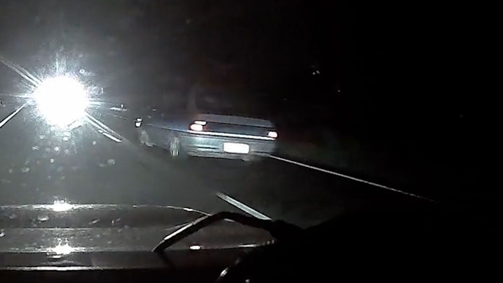 A driver believed to be under the influence is filmed after passing a police car — and narrowly missing a head-on collision with another vehicle — in Queensland, Australia. (Queensland Police/Zenger)