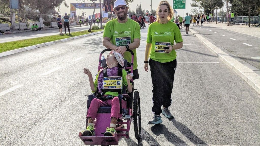 Aryeh Holtz at the International Jerusalem Marathon with twin daughters Miri and Leah. He built Leah’s running stroller from scratch. (Courtesy of ADI)