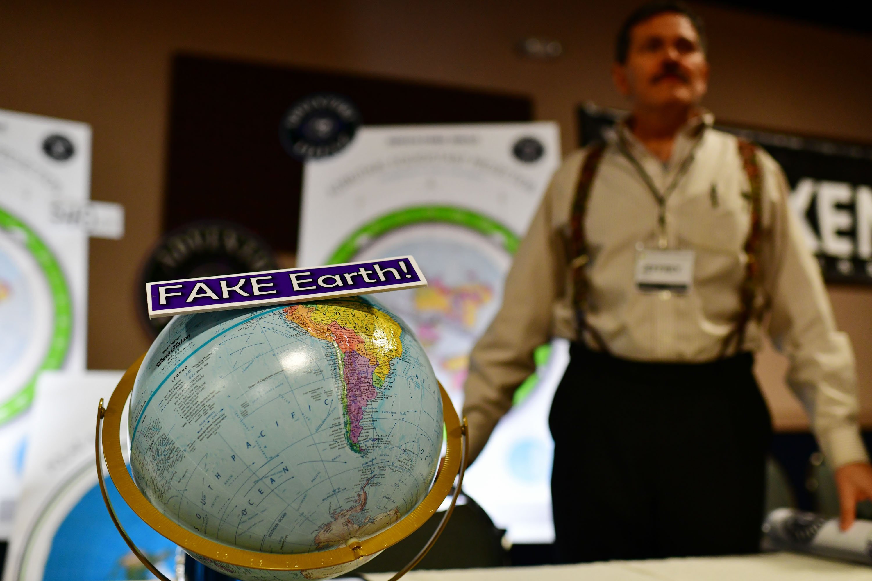 Jeffrey Diaz, right, is selling flat earth maps at his booth during Flat Earth International Conference at Crowne Plaza Denver Airport. Hundreds of people who believe the Earth is flat attended the conference.