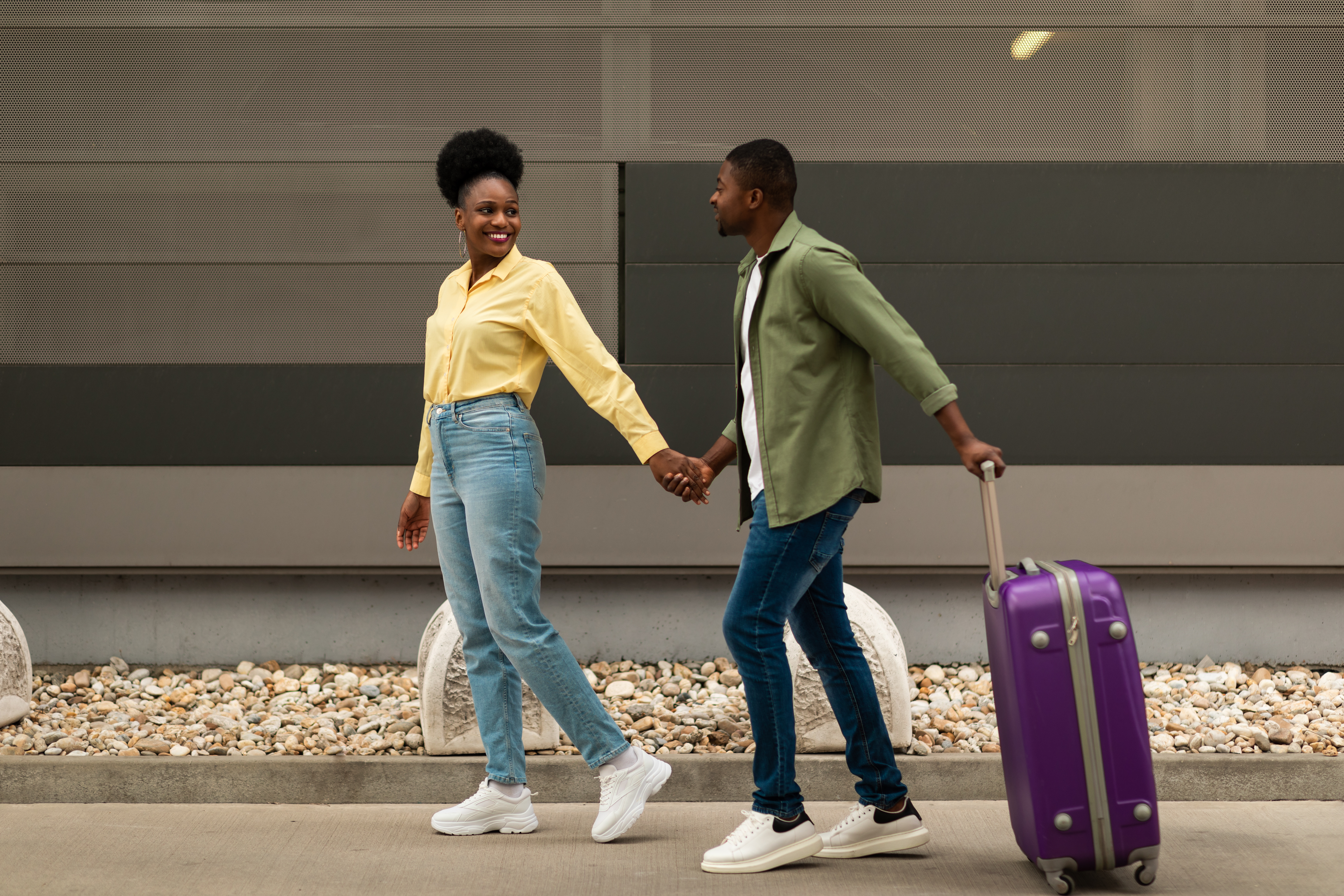 Two tourists walking with their luggage