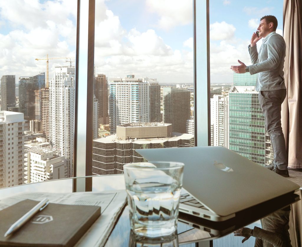 Businessman standing next to a large glass window in his office.