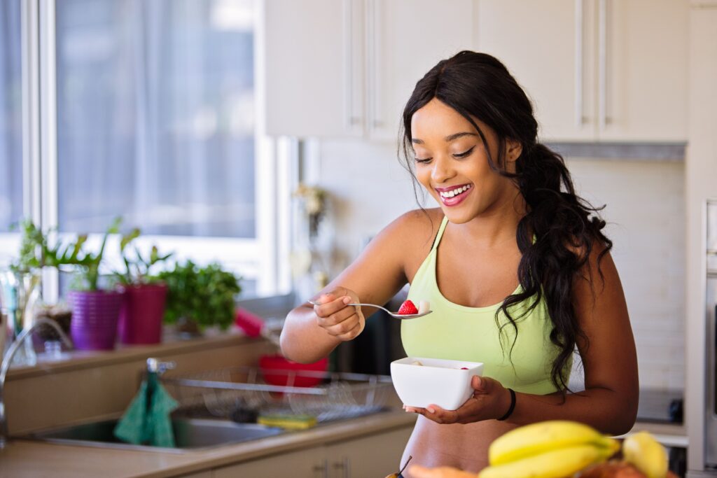 Smiling woman eating a nutritious fruit bowl