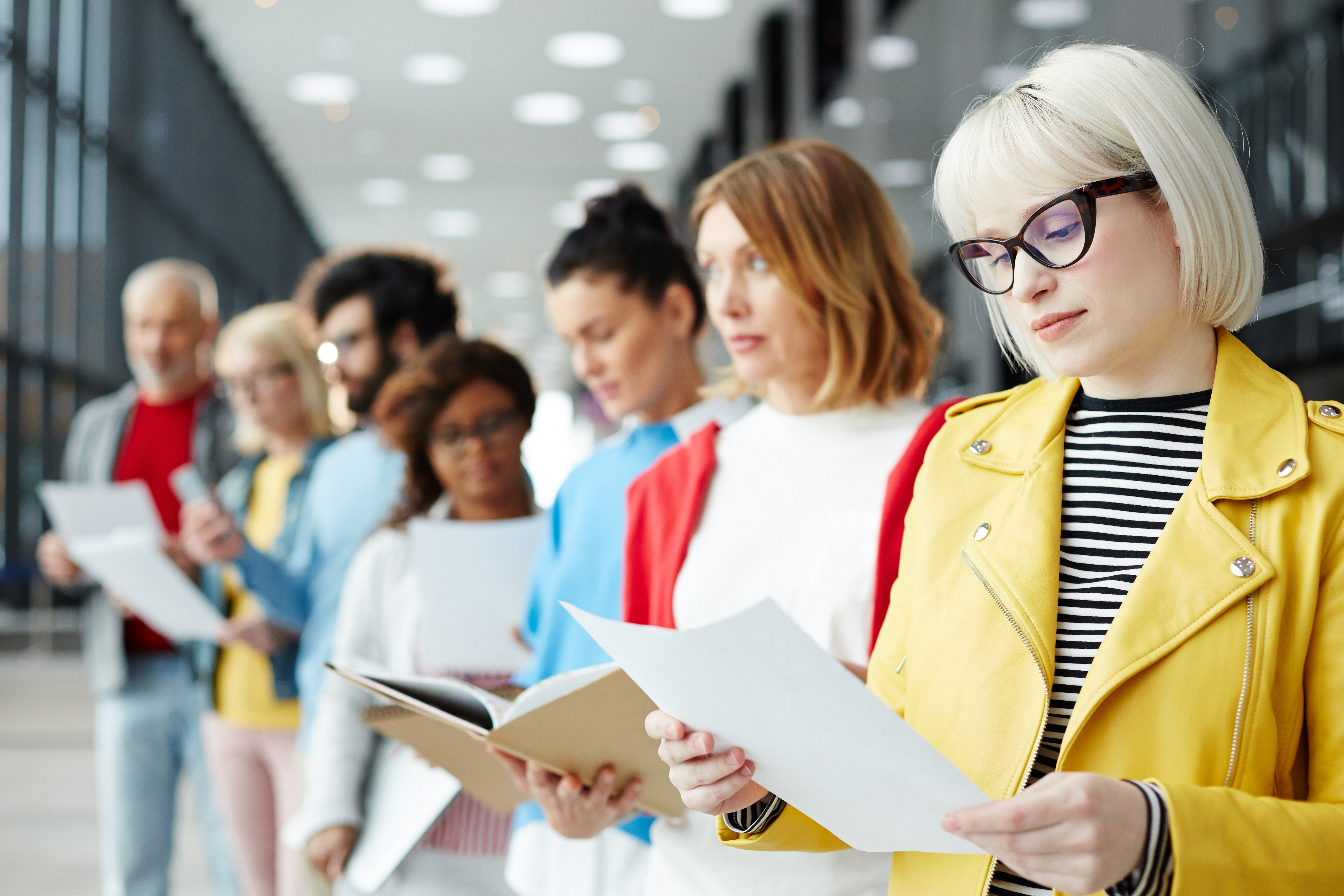 Young woman reading her resume while standing in queue and waiting for her turn for interview. (Photo by: Pressmaster | elements.envato.com)